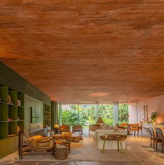 a living room filled with lots of furniture and walls covered in wooden planks on the ceiling