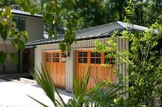 two garages in front of some trees and bushes