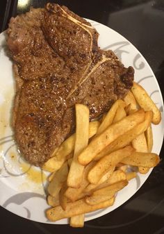 steak and french fries on a white plate