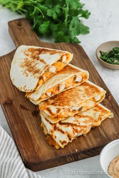 several quesadillas stacked on a cutting board