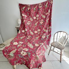 a chair with a pink blanket on top of it next to a white wall and floor