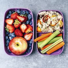 two plastic containers filled with food on top of a cement floor next to carrots, celery and strawberries