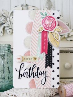 a birthday card sitting on top of a table next to a vase and yarn spool