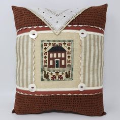 a brown and white pillow with a house on it