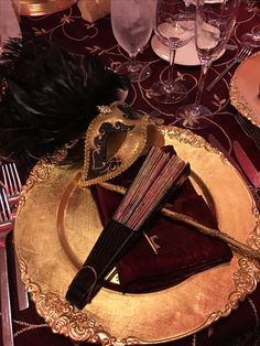 a fancy table setting with red and gold place settings