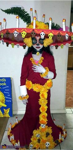 a woman dressed up in a costume with skulls on her head and flowers all over her body