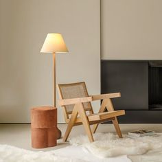 a wooden chair sitting in front of a fire place next to a lamp on a table