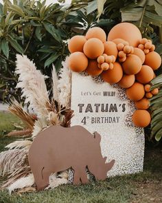 an elephant and rhinoceros are on display in front of a sign