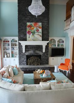 a living room filled with furniture and a fire place in the middle of a room