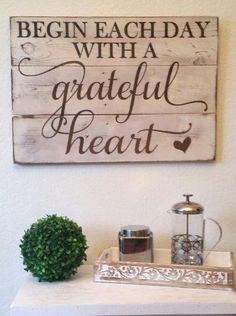 a sign that says begin each day with a grateful heart on top of a table