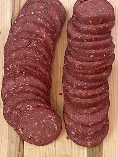 a pile of sausage sitting on top of a wooden cutting board