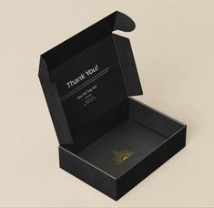 an open black box with the words thank you on it and a gold sun design