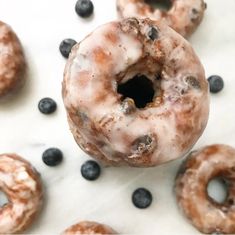 several donuts with blueberries and icing on a table