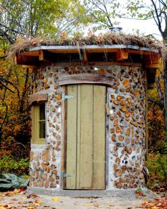 an outhouse made from rocks and logs in the woods