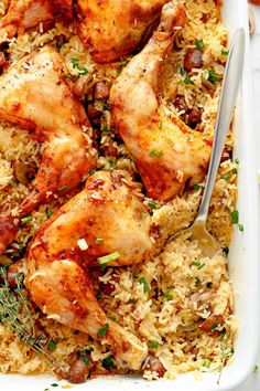 chicken and rice in a casserole dish with a serving spoon on the side