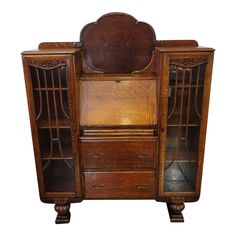 an antique wooden cabinet with glass doors