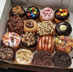 a box filled with lots of different flavored donuts