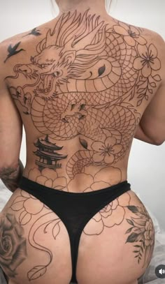 the back of a woman's body with tattoos on her chest and bottom half