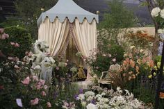 a white gazebo surrounded by lots of flowers