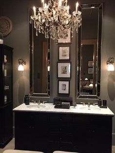 a bathroom with two sinks and a chandelier in the middle of the room