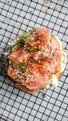 a bagel covered in salmon and cheese on a wire cooling rack with sprinkles