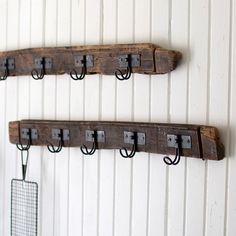 three wooden pegs are hanging on the wall next to each other with metal hooks