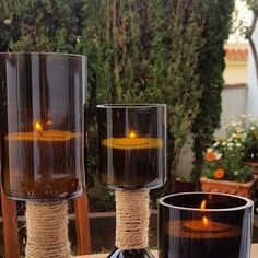 two vases with candles in them sitting on a table