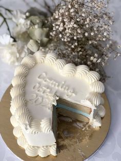 there is a cake that has been cut in half on the table with flowers behind it