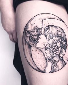 a woman's thigh with a skull and flower tattoo on it