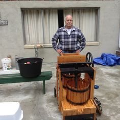 a man standing next to a wooden barrel