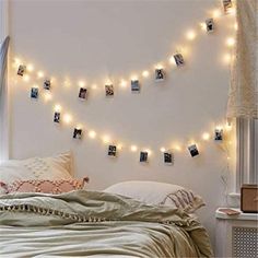 a bedroom with string lights and pictures on the wall