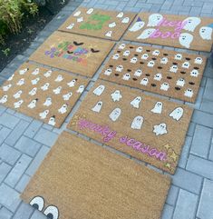 halloween doormats on the sidewalk with ghost faces and words written in different colors