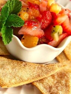 a white bowl filled with fruit and crackers