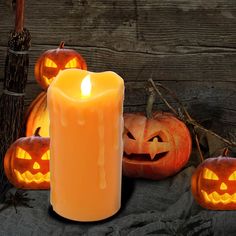 three carved pumpkins and one lit candle