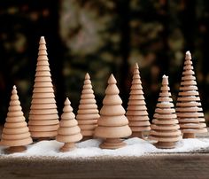 small wooden trees are lined up in the snow