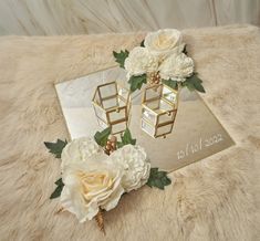 two white flowers sitting on top of a fur covered floor next to a mirrored mirror