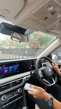 a woman driving a car with her hands on the steering wheel