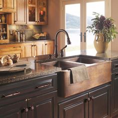 a large kitchen with wooden cabinets and granite counter tops is pictured in this image, there are two sinks on the center island