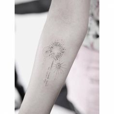 a woman's arm with a dandelion tattoo on the left side of her arm