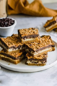 several pieces of dessert on a plate with chocolate chips and coffee beans in the background