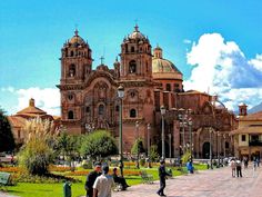 people are walking around in front of a large building with many towers and domes on it