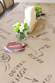 the table is covered with writing and flowers in small vases on top of it