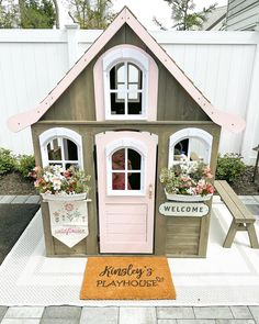 a pink and brown doll house sitting on top of a wooden bench next to a welcome mat