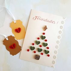 two greeting cards with hearts and buttons attached to the front of each card are on a white table