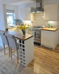 a kitchen with white cabinets and an island in front of a stove top oven next to a dining room table