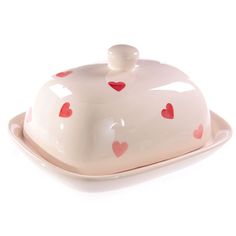 a white cake dish with red hearts on it