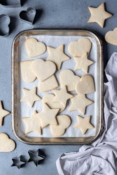 cut out sugar cookies on a baking sheet with star shaped cookie cutters and icing