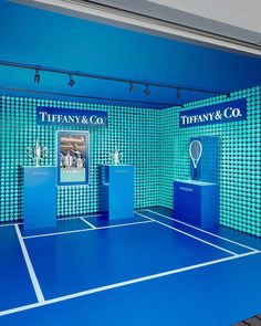 there is a tennis court with blue tiles on the wall and white lines on the floor