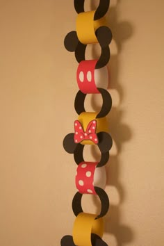 a mickey mouse and minnie mouse head hanging on a wall with paper streamers attached to it