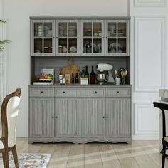 a dining room table and chairs in front of a gray china cabinet